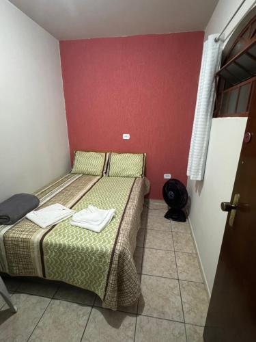 - 2 lits dans une petite chambre aux murs rouges dans l'établissement Quarto Guararema 2, à Guararema