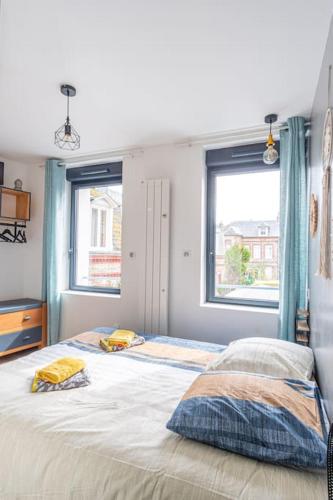 une chambre avec un lit avec deux oreillers dessus dans l'établissement La Maison d’Albâtre - Plage d'Yport - 3 étoiles, à Yport
