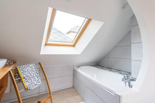 une salle de bain avec une baignoire et une fenêtre dans l'établissement La Maison d’Albâtre - Plage d'Yport - 3 étoiles, à Yport