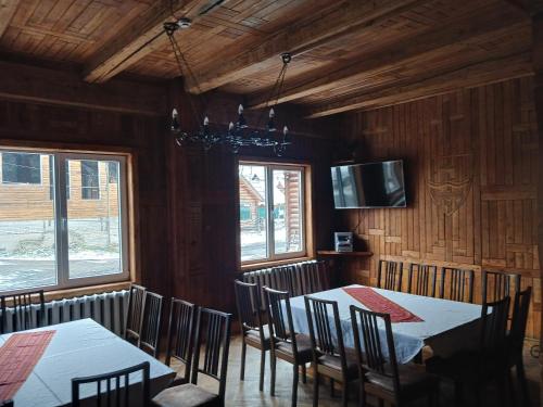 a dining room with tables and chairs and a tv at Едельвейс-Будапешт in Yasinya