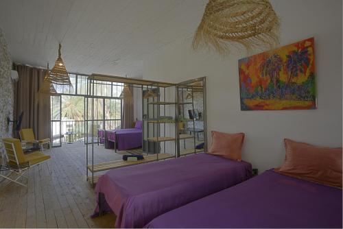 a bedroom with two beds with purple sheets at dar seddik in Gafsa