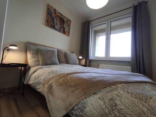 a bedroom with a large bed with a window at ***Santorini Apartament*** - 40m² ✓ in Rybnik