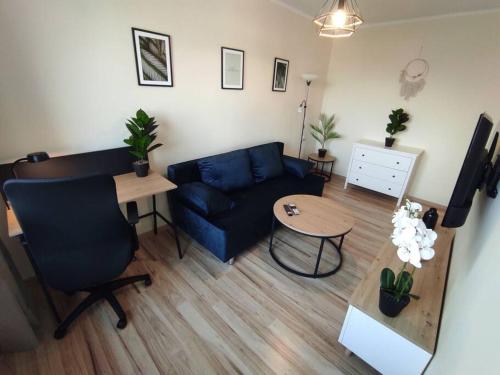 a living room with a blue couch and a table at ***Santorini Apartament*** - 40m² ✓ in Rybnik