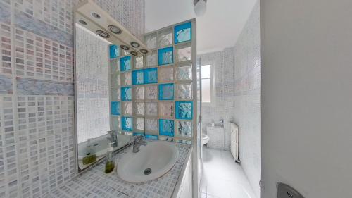 La salle de bains est pourvue d'un lavabo et d'un miroir. dans l'établissement Superbe appartement à La Garenne Colombes, à La Garenne-Colombes