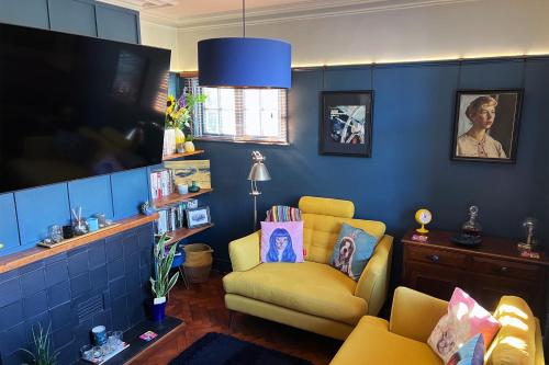 a living room with a yellow chair and a tv at 1880s Soap Worker's Cottage, Port Sunlight in Port Sunlight