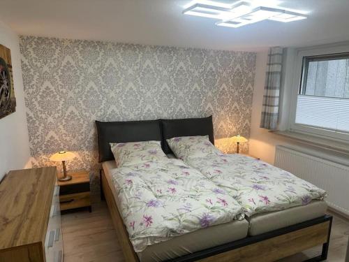a bedroom with a bed and a table with two lamps at Ferienwohnung Klee in Neheim-Hüsten