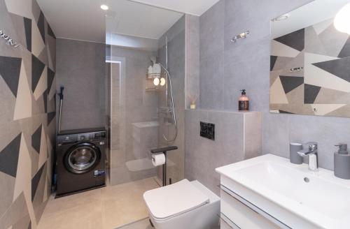 a bathroom with a toilet and a washing machine at Revalia Lastekodu Bus-Station Airport Studio in Tallinn