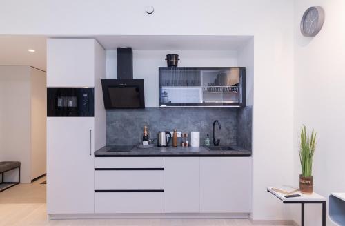 a kitchen with white cabinets and a counter at Revalia Lastekodu Bus-Station Airport Studio in Tallinn
