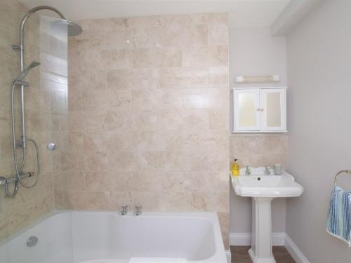 a bathroom with a white tub and a sink at 3 Bed in Brixham 75230 in Brixham