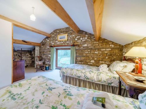 1 Schlafzimmer mit 2 Betten und einer Steinmauer in der Unterkunft 2 Bed in Sedbergh 57641 in Dent