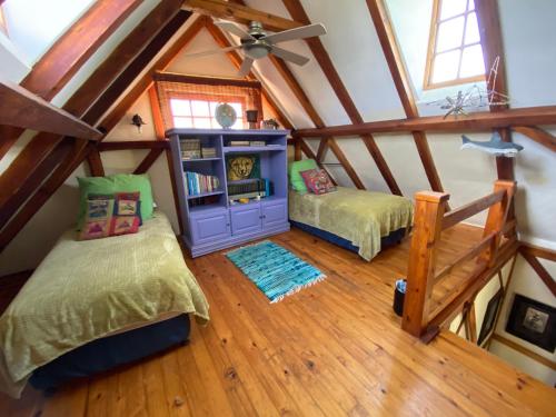 um quarto no sótão com 2 camas e um tecto em Bohemian Garden Cottages em Kaapsehoop