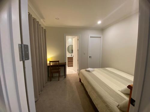 a hotel room with a bed and a desk at Auckland GQ Flat bush holiday home in Auckland