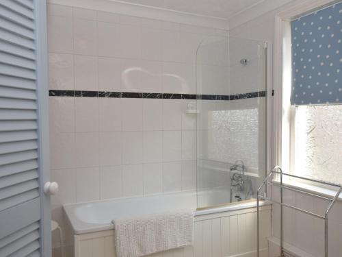 a white bathroom with a tub and a window at 3 bed in Eastbourne EHC04 in Eastbourne