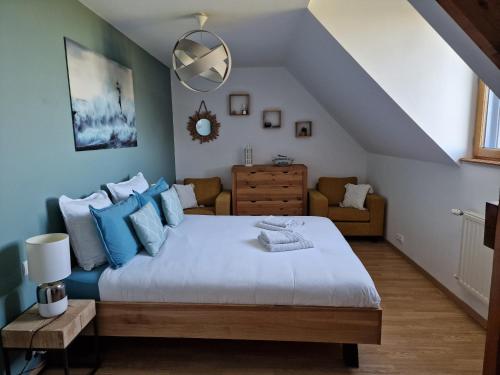 1 dormitorio con 1 cama grande con almohadas azules en L'Aurore de la Baie, vue sur le Mont-Saint-Michel en Huisnes-sur-Mer