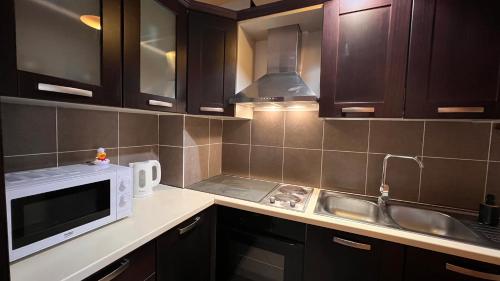 een keuken met een magnetron en een wastafel bij Mikael Apartment in Durrës