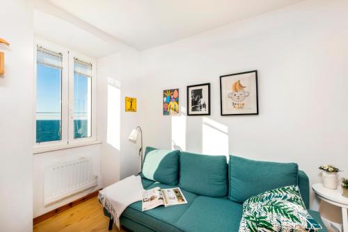 a living room with a blue couch and a window at Apartman Beppo in Rovinj