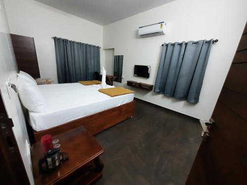 um quarto de hotel com uma cama e uma televisão em Tamora By avea em Madurai