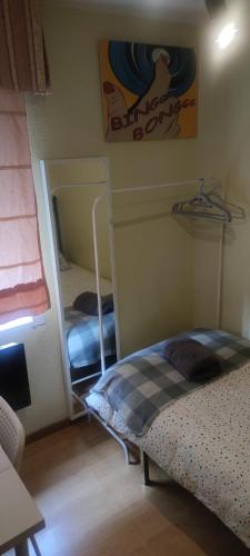 1 dormitorio con 2 literas y espejo en Habitacion individual en apartamento céntrico, en Madrid