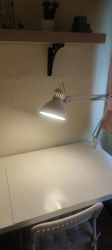 Habitacion individual en apartamento céntrico في مدريد: ضوء على رف فوق طاولة بيضاء