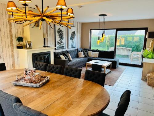 comedor y sala de estar con mesa de madera en Maison - Le Sable Doux, en Middelkerke