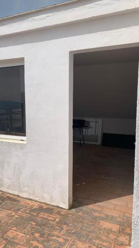 an empty garage with a white wall and a table at La Pontezuela in Chipiona