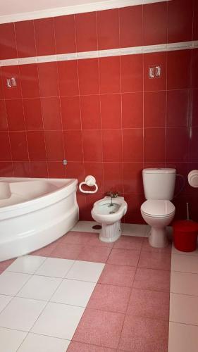 a red bathroom with a tub and a toilet and a sink at La Pontezuela in Chipiona