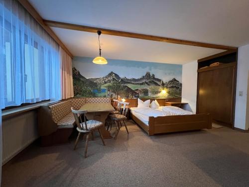 een hotelkamer met een bed en een tafel en stoelen bij Gästehaus Tauscher am Haldensee in Haldensee