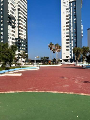 a red tennis court in a city with tall buildings at Apartamento atardecer dorado in Valencia