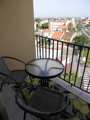 une table et des chaises sur un balcon avec vue dans l'établissement GOELETTE appartement climatisé, équipé du wifi et parking gratuit en haute saison, à Canet