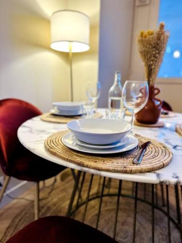 une table avec des assiettes et des verres à vin dessus dans l'établissement Le Haut Mabilais - Centre Rennes, à Rennes