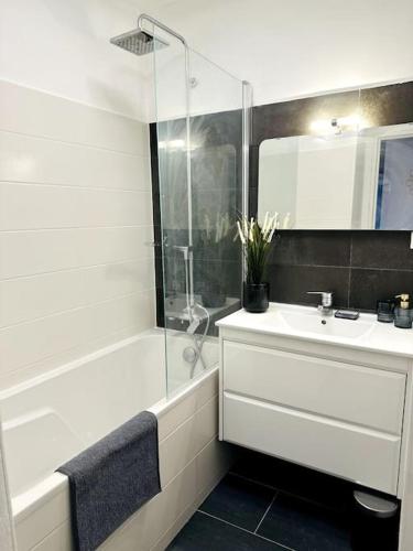 une salle de bain blanche avec un lavabo et une douche dans l'établissement Le Haut Mabilais - Centre Rennes, à Rennes