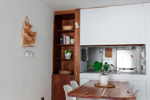 cocina con mesa de madera y sillas blancas en Departamento dúplex frente al mar en Reñaca, en Viña del Mar