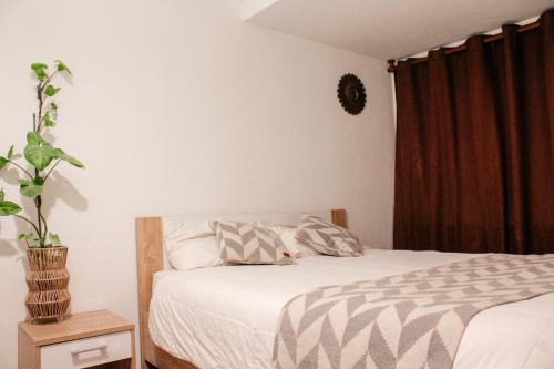ein Schlafzimmer mit einem Bett und einer Topfpflanze in der Unterkunft Departamento dúplex frente al mar en Reñaca in Viña del Mar