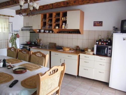 a kitchen with a table and a refrigerator at Pensiunea Casa Filoxenia in Horezu