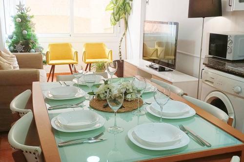 a dining table with plates and wine glasses on it at Apartamento en Roda de Berà in Roda de Bará