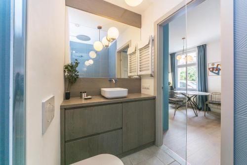La salle de bains est pourvue d'un lavabo et d'un miroir. dans l'établissement DR Apartments - Salt, à Sopot