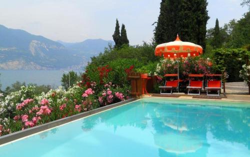 a swimming pool with a gazebo and flowers at Appartamenti Le Dimore 2 in Torri del Benaco