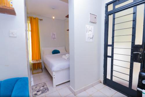 a small room with a bed and a window at Cozy Studio along Ngong road-Nairobi in Nairobi