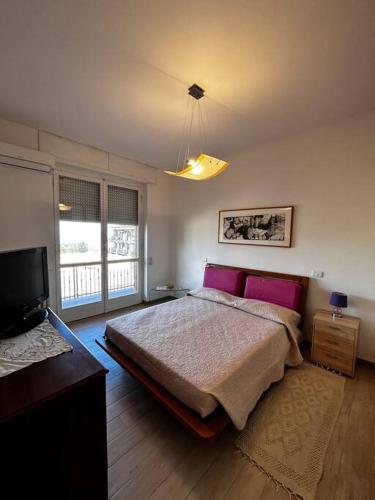 a bedroom with a bed with purple pillows and a tv at Appartamento Sarteano in Sarteano