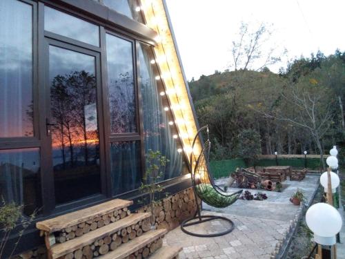 a house with a large window on a patio at Cottage "Sunset" in Batumi