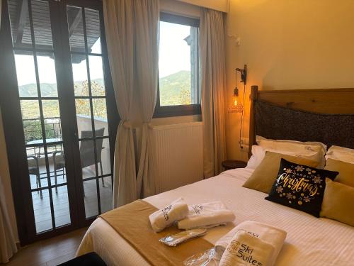 カラブリタにあるSki Suites - A Luxury Maisonette Kalavrytaのベッドルーム1室(ベッド1台、タオル2枚付)