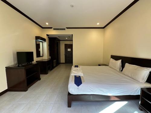 a bedroom with a bed and a flat screen tv at Baan Kingkeaw Thamdee Patong in Patong Beach