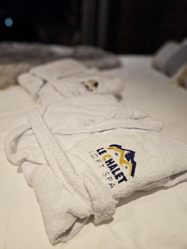 two white towels sitting on top of a bed at Le Chalet Loft Spa in Calais
