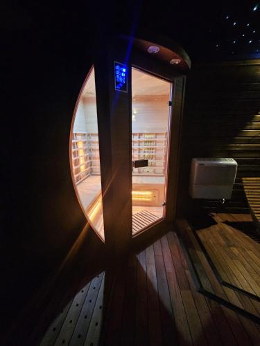 a room with a round mirror on a boat at Le Chalet Loft Spa in Calais