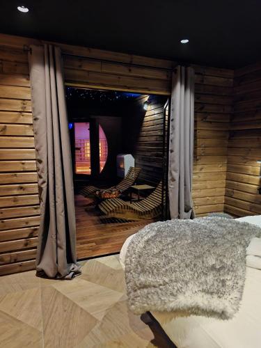 a bedroom with a window with curtains and a bed at Le Chalet Loft Spa in Calais