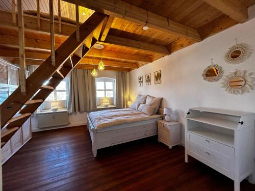 ein Schlafzimmer mit einem Bett und einer Holztreppe in der Unterkunft Storchenhof in Eutin