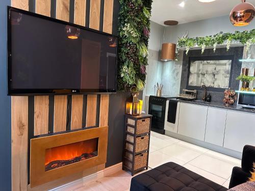 a living room with a fireplace and a flat screen tv at Botanica @ The.Villas.Newcastle in Elswick