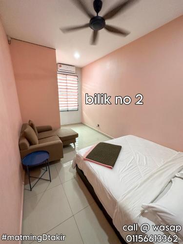a bedroom with a bed and a chair and a ceiling fan at MatmingDtakir (near beach & drawbridge) in Kuala Terengganu