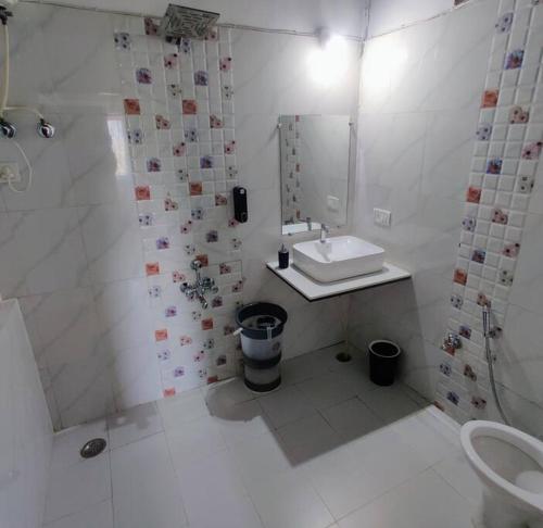 a white bathroom with a sink and a shower at Valley Nest for 6-12 PAX in Mount Ābu