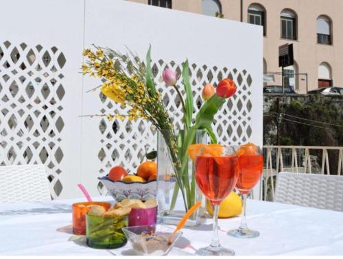 una mesa con dos copas de vino y un jarrón de flores en Ti racconto il mare, en Salerno